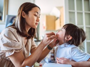 一位母亲在家中对蹒跚学步的孩子进行COVID-19检测