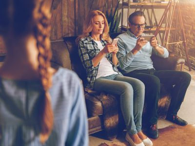 parents busy on smartphones while young child waits for attention