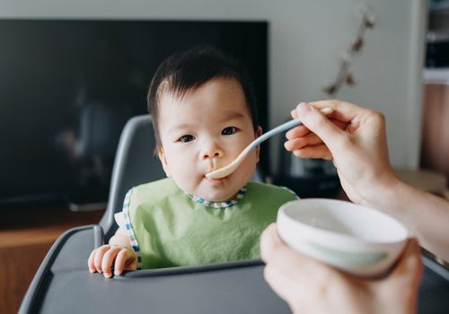 婴儿坐在高脚椅上喂奶