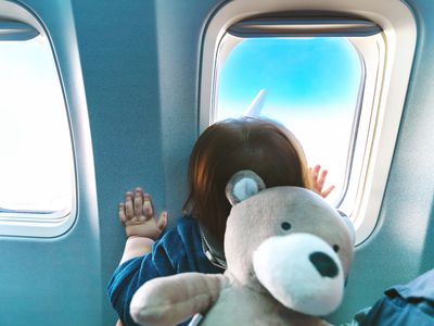 Toddler looking out airplane window