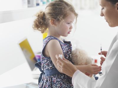 Doctor giving toddler girl a shot