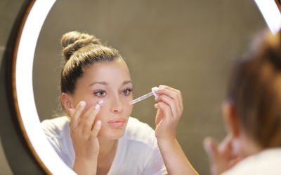 Woman applying face serum.