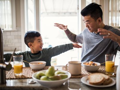 Father and son having breakfast in kitchen