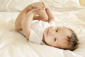 9个月大的男婴躺下从出生到一年的母乳喂养阶段