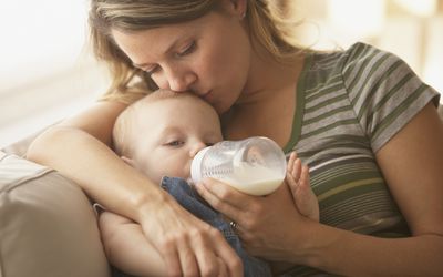 Parent feeding baby a bottle