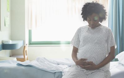 在医院抱着肚子的非洲裔美国孕妇