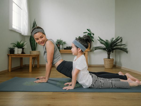 A mother doing yoga with her daughter