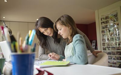 Girl studying with her mother at home