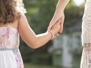 mother and young daughter holding hands