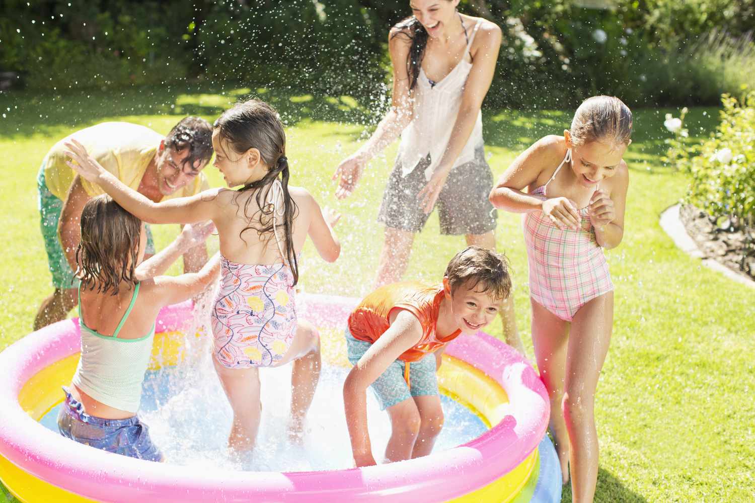 Family playing outdoors in a blow-up kiddie pool