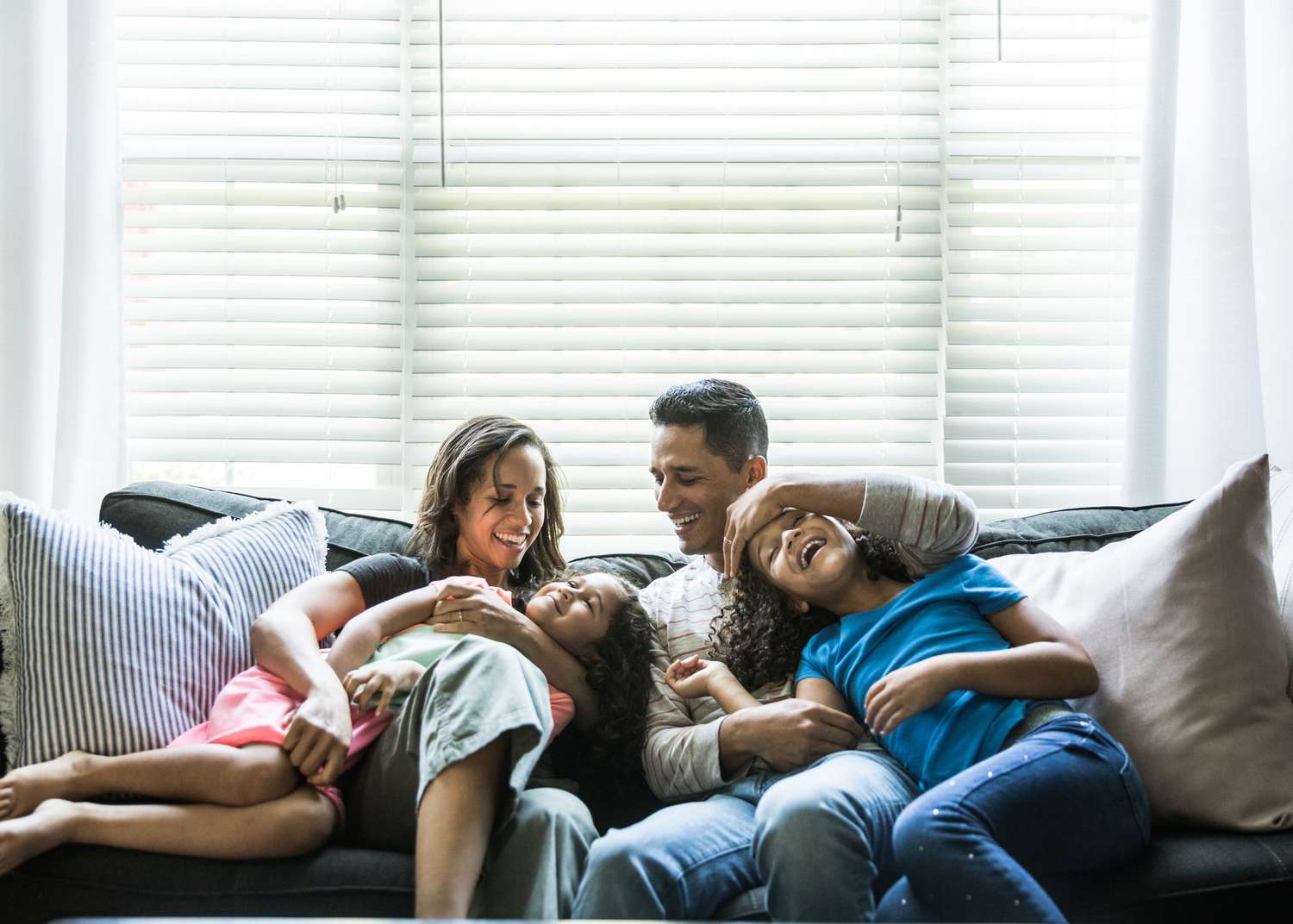 family smiling, being playful on the couch