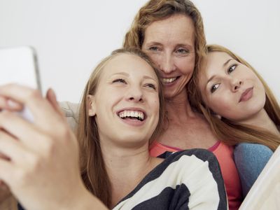 A mother and her teen daughters laughing