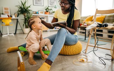 woman braiding a child's hair