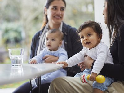 Mothers and babies in kitchen talking