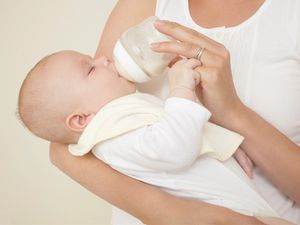 母亲给刚出生的婴儿喂奶瓶