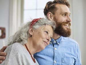 Mother and smiling adult son