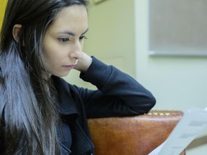 Young woman looking at a college rejection letter