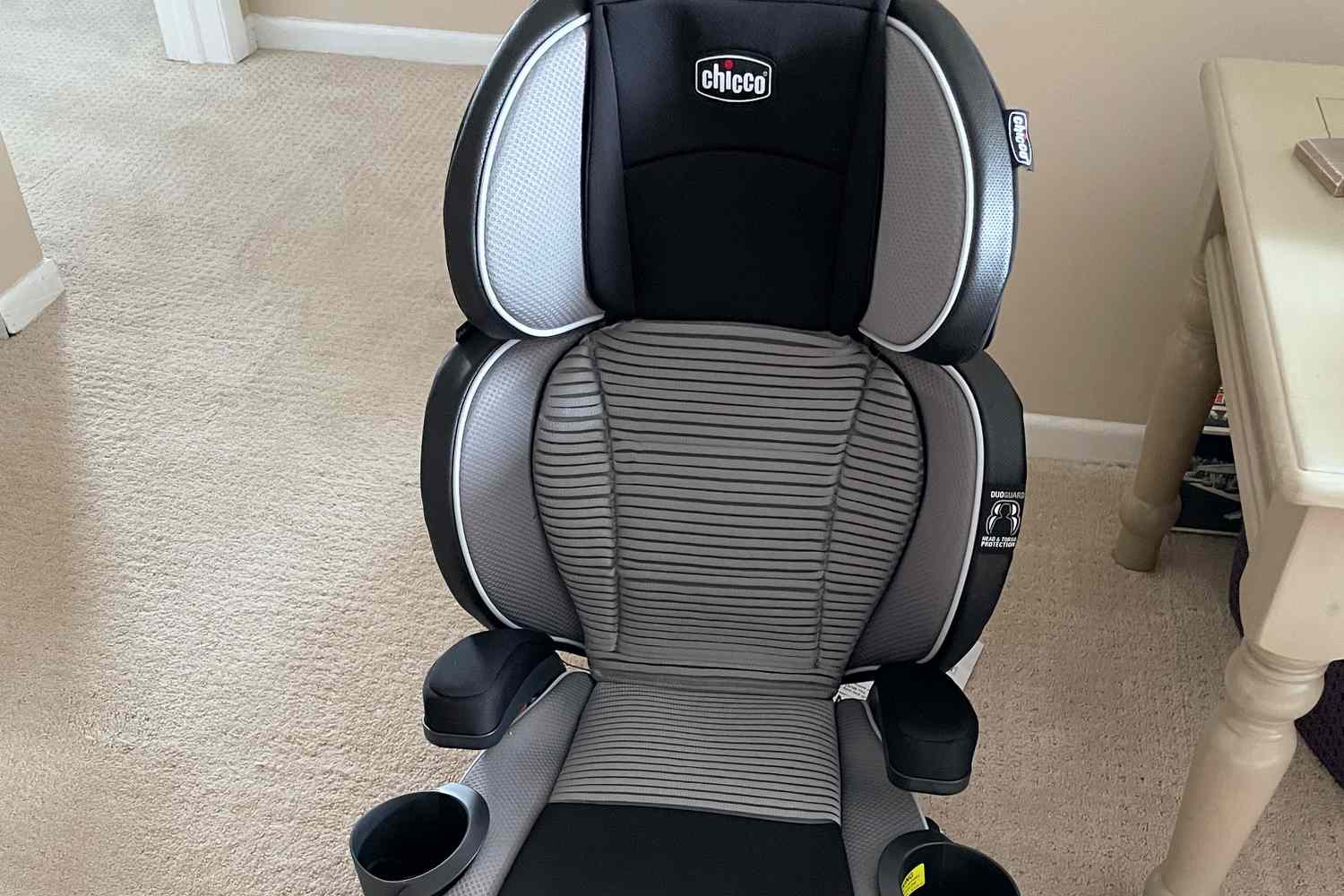 The Chicco KidFit Zip Air Plus 2-in-1 Belt-Positioning Booster Car Seat on a carpeted floor