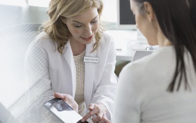 Doctor and patient looking at digital tablet