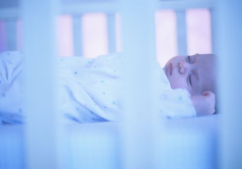 Baby in crib sleeping on back