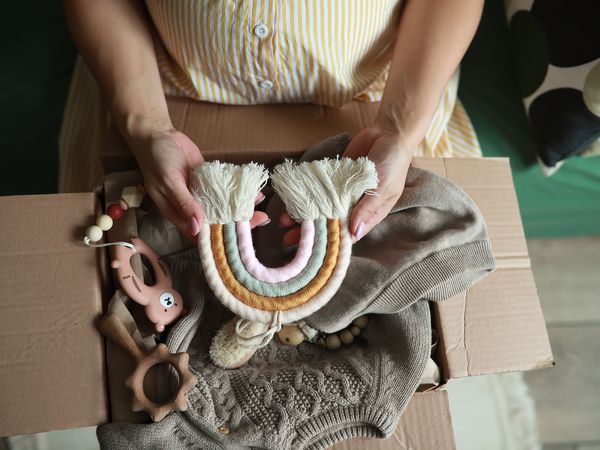 Young pregnant woman with parcel with things for newborn