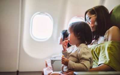 woman holding toddler on airplane
