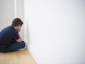 boy in sitting in corner in time out