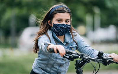 戴着面具骑自行车的女孩