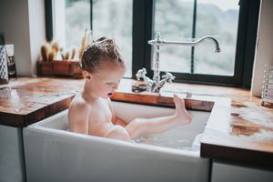 young boy bathing in kitchen sink