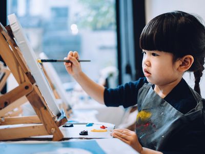 A toddler experimenting with color during their art class