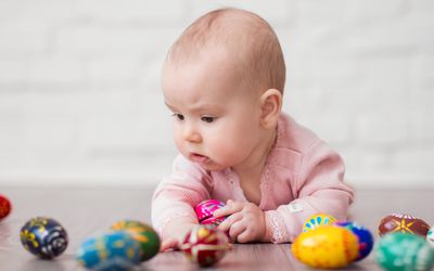 肚子上的小婴儿在玩彩绘的鸡蛋，比喻卵子捐赠者的受孕和选择