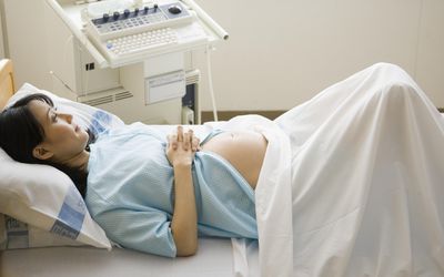 孕妇躺在医院的床上，高架视图