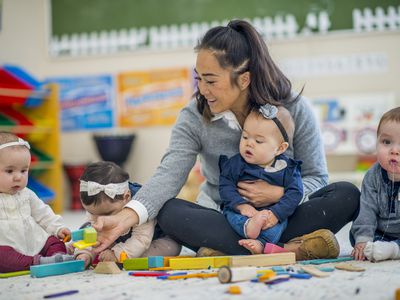 Pre school teacher playing with babies