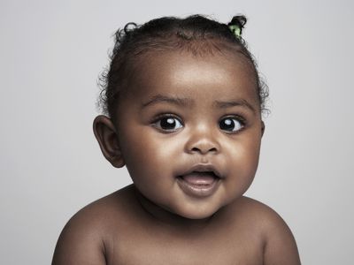 Baby girl (6-9 months) smiling, portrait - stock photo