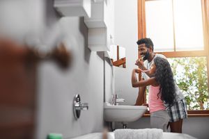 dad and daughter brushing teeth together