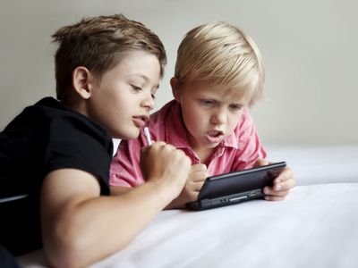 boys play handheld video game