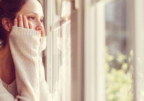 穿白毛衣的女人望着窗外。