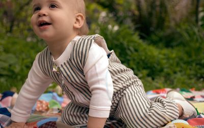 Baby crawling on a blanket outside