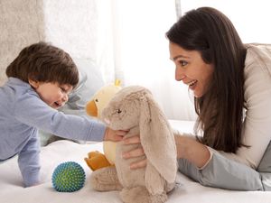 Mom and toddler boy playing with stuffed animals