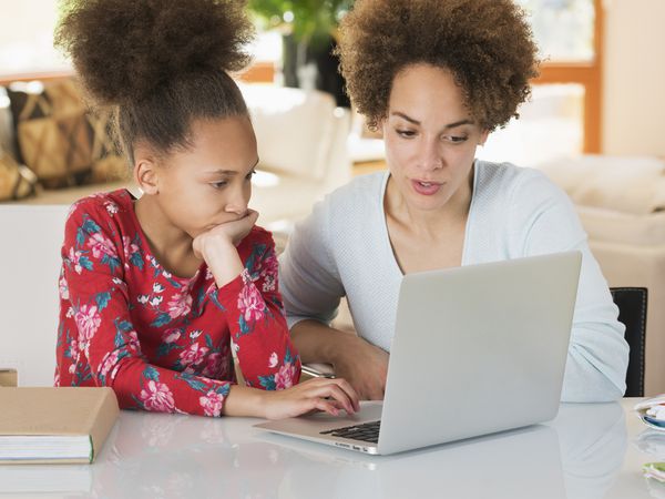 young girl and mom using laptop together