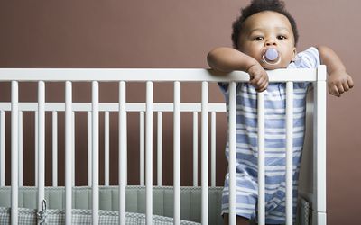 baby boy standing in a cot