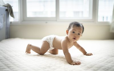 baby crawling on a bed