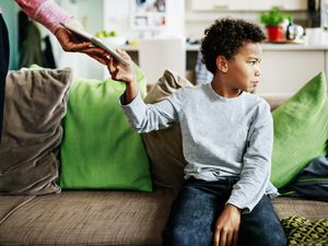 A father punishes his son by taking his tablet off him for playing on it too long.