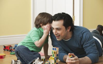 一个小男孩在他爸爸耳边低语