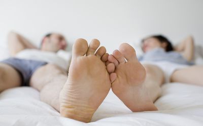 情侣的脚在床上接触