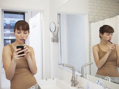 Woman using phone in the bathroom
