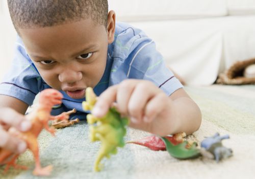 男孩在玩恐龙雕像