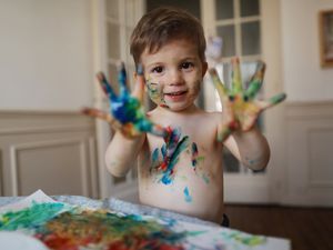 little boy using finger paints