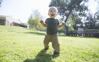 小男孩正在草地上学习走路