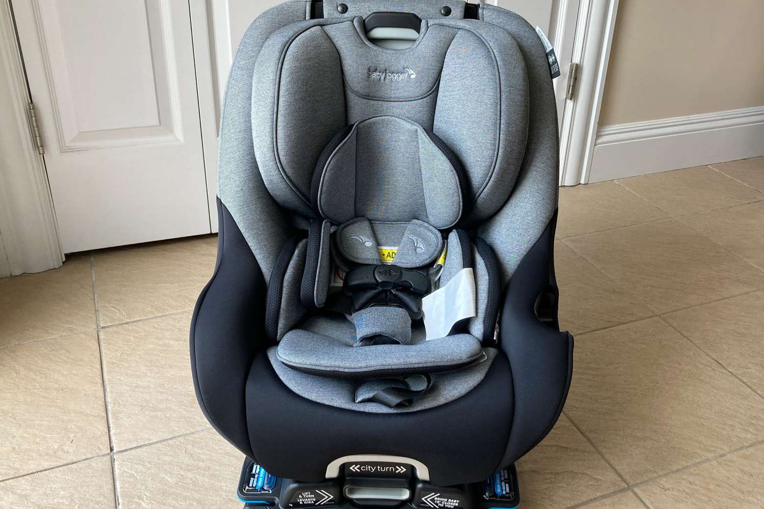 The Baby Jogger City Turn Rotating Convertible Car Seat on a tile floor